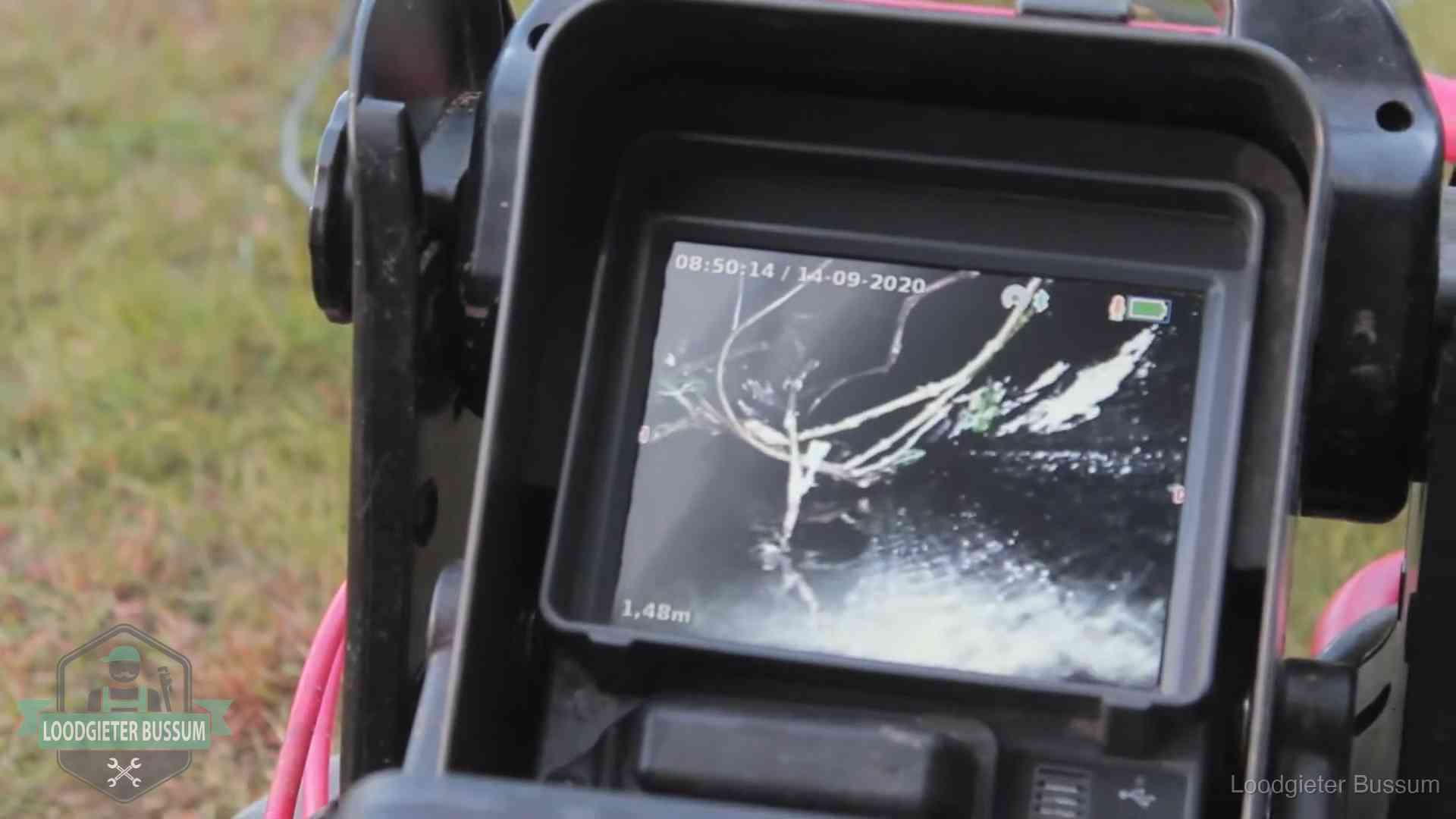 Monitor van een rioolcamera toont wortelingroei in de rioolbuis bij een woning in Bussum