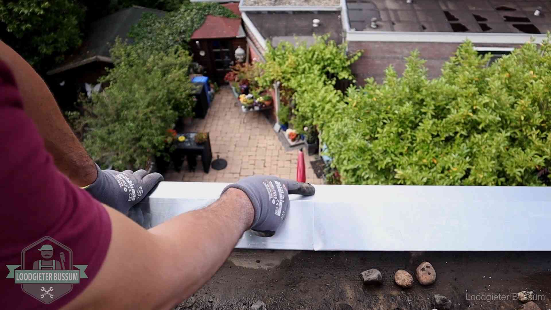 Daklekkage geregeld in Bussum Vakman plaatst een daktrim op de dakrand van een woning in Bussum