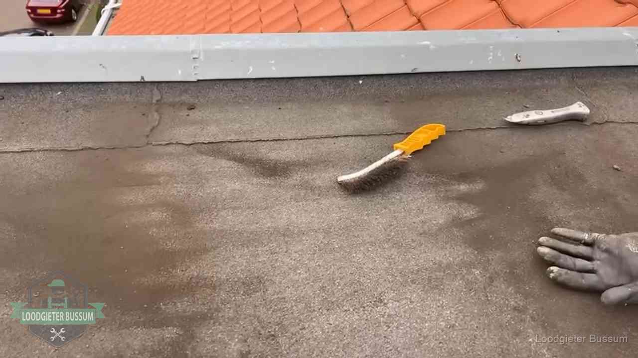 Kosten van daklekkage-reparatie in Bussum Dakdekker bereidt een bitumen plat dak voor op reparatie bij de daktrim in Bussum