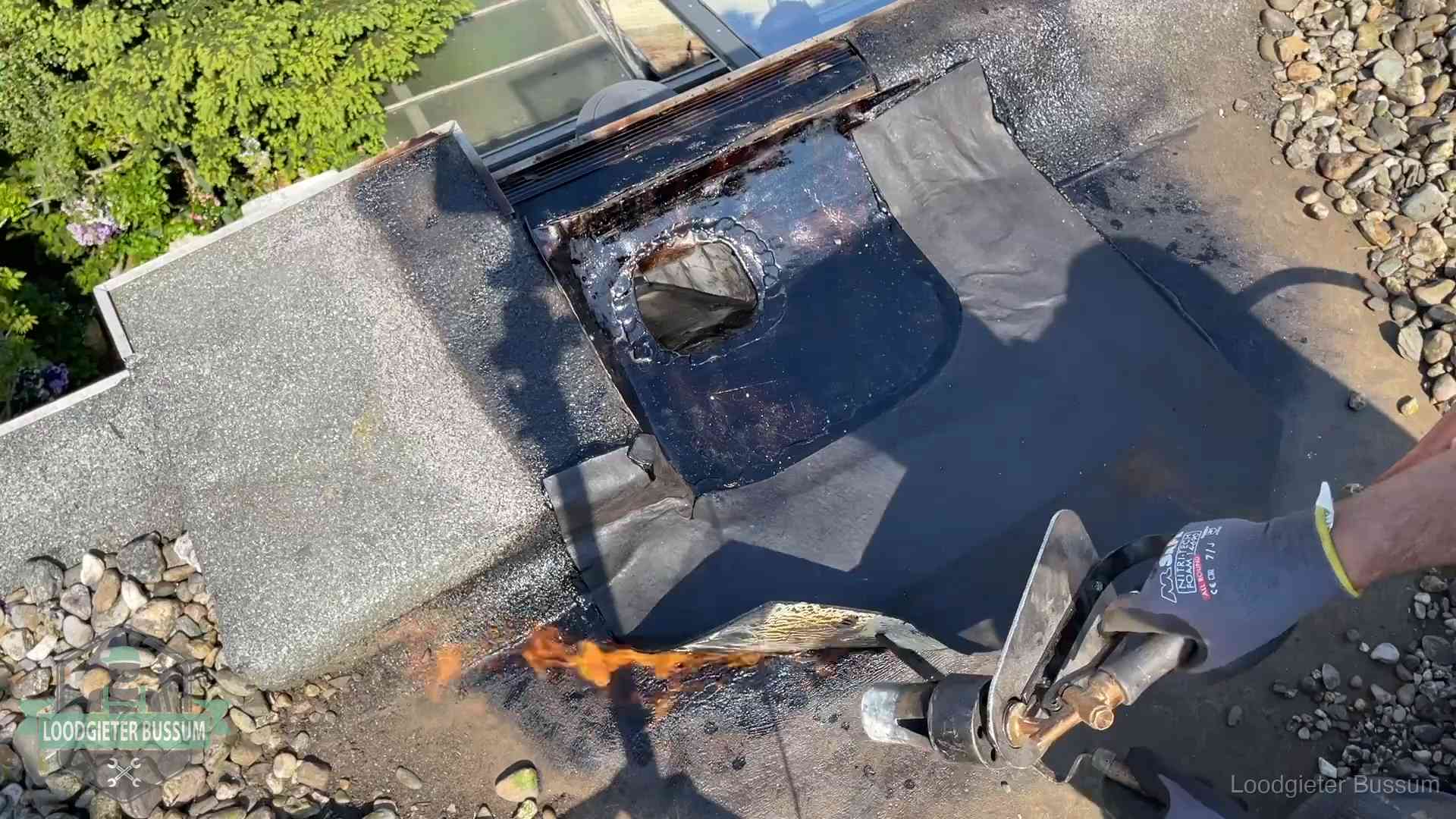 Daklekkage repareren in Bussum Dakdekker brandt bitumen rond een doorvoer tijdens een daklekkage-reparatie in Bussum