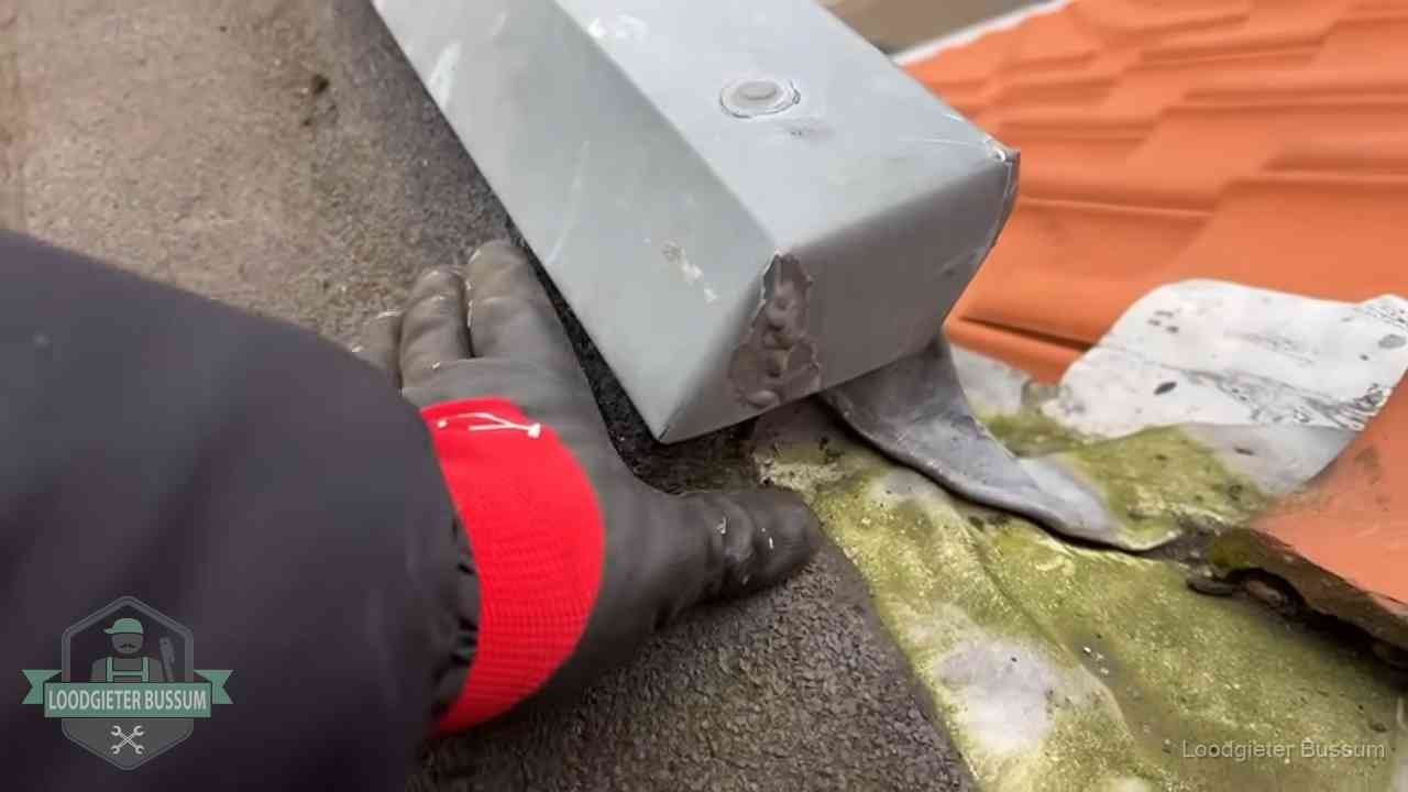 Hemelwaterafvoer en dakgoot controleren in Bussum Controle van een zinken hemelwaterafvoer met loodslab bij dakpannen in Bussum