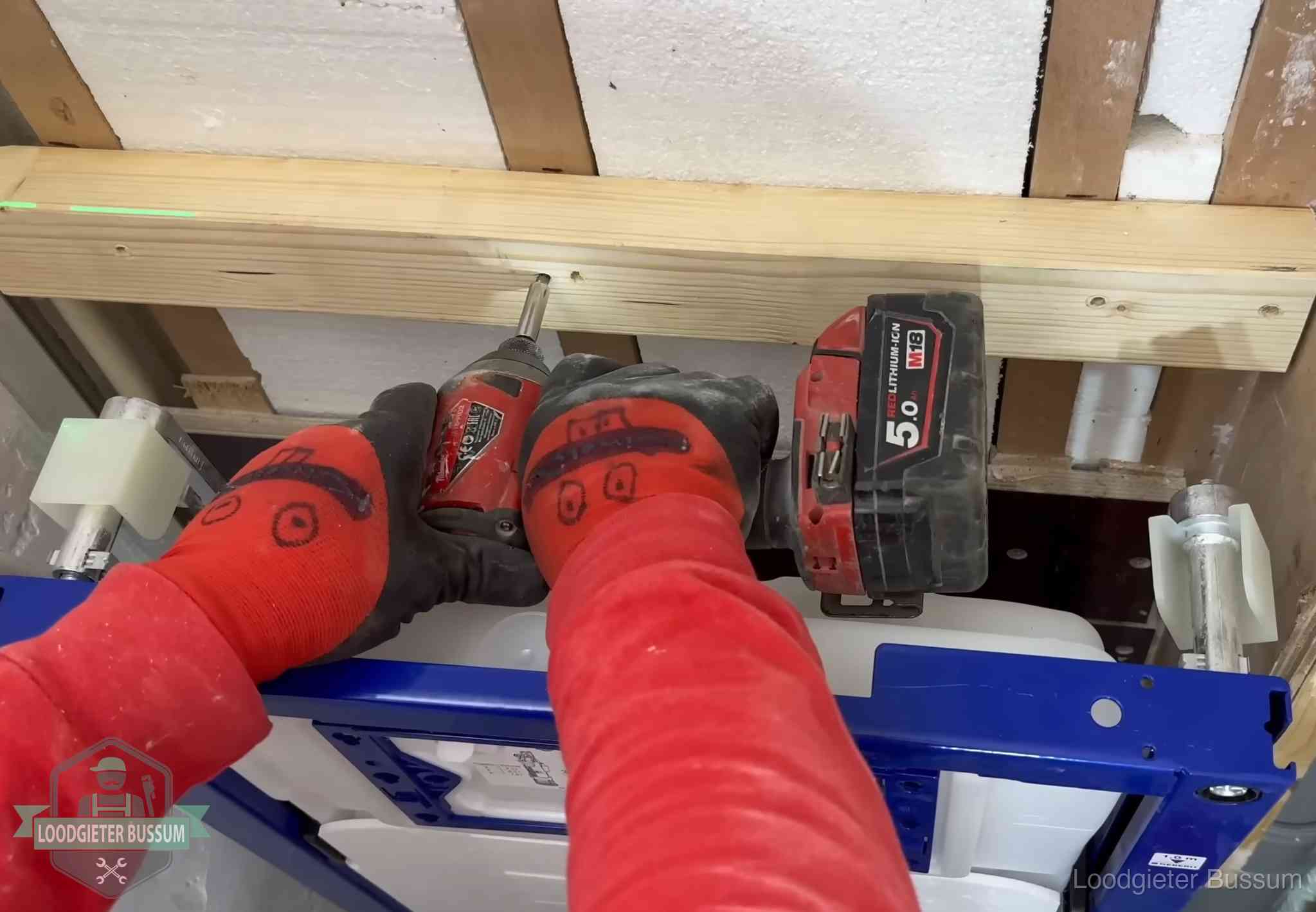 Monteur bevestigt een inbouwreservoir voor een hangend toilet in Bussum