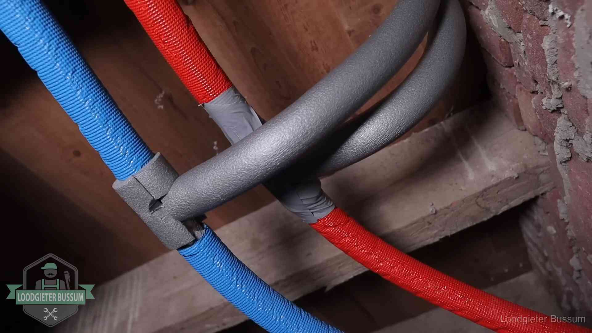 Geïsoleerde waterleidingen langs houten balken tegen bevriezing in Bussum