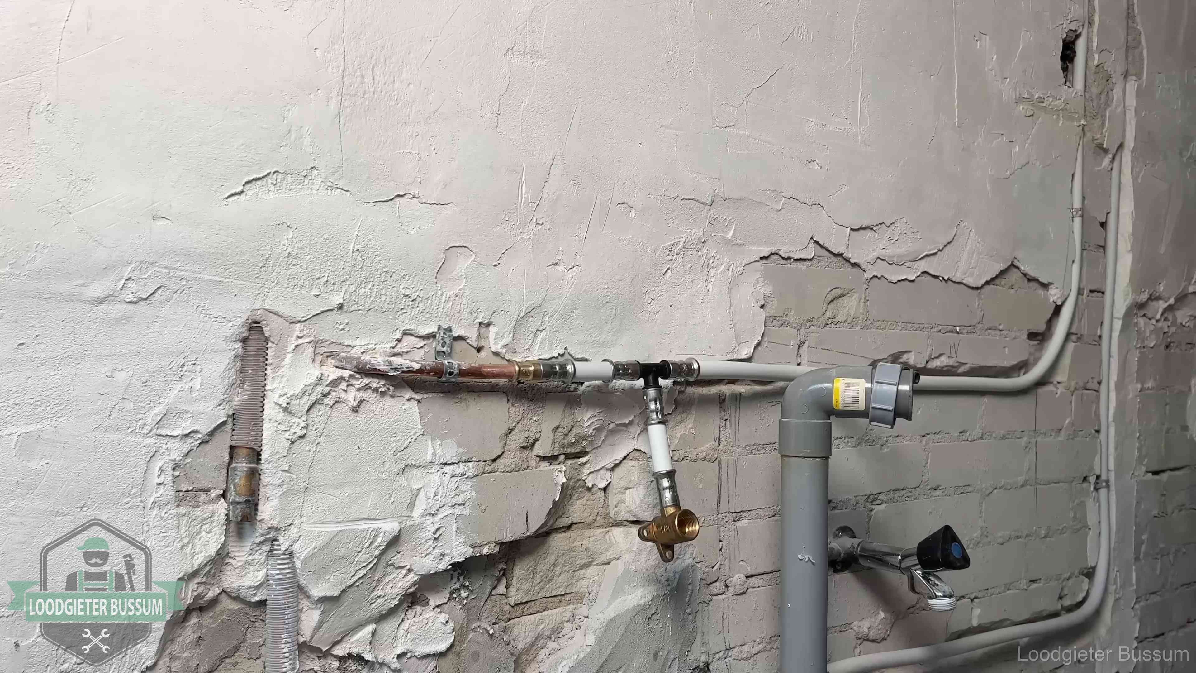 Nieuw leidingwerk naast een oud verroest leidingrestant in een woning in Bussum