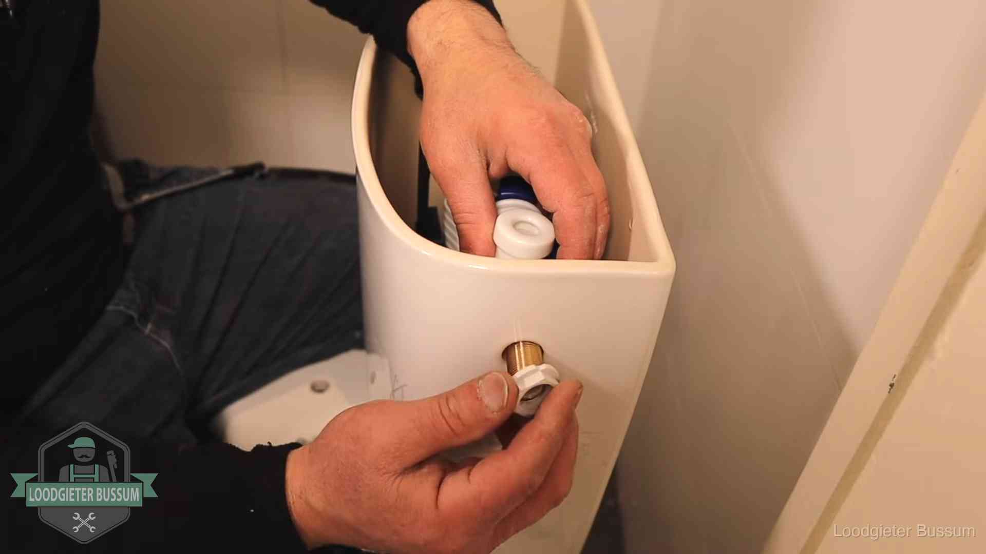 Loodgieter monteert de vlotterkraan van een stortbak bij een toilet in Bussum