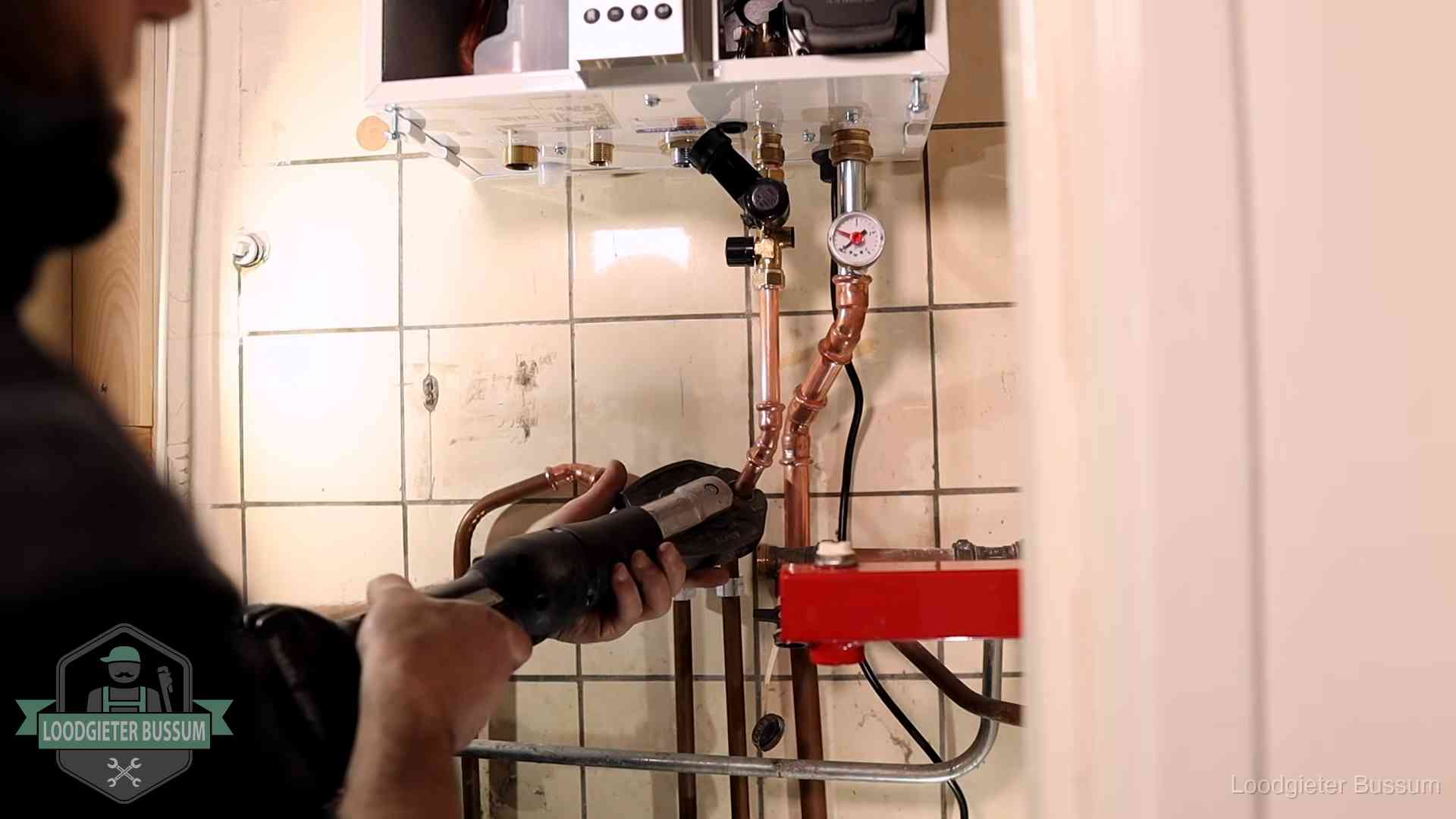 Cv-ketel onderhoud in Bussum Monteur werkt aan de leidingen onder een cv-ketel in Bussum
