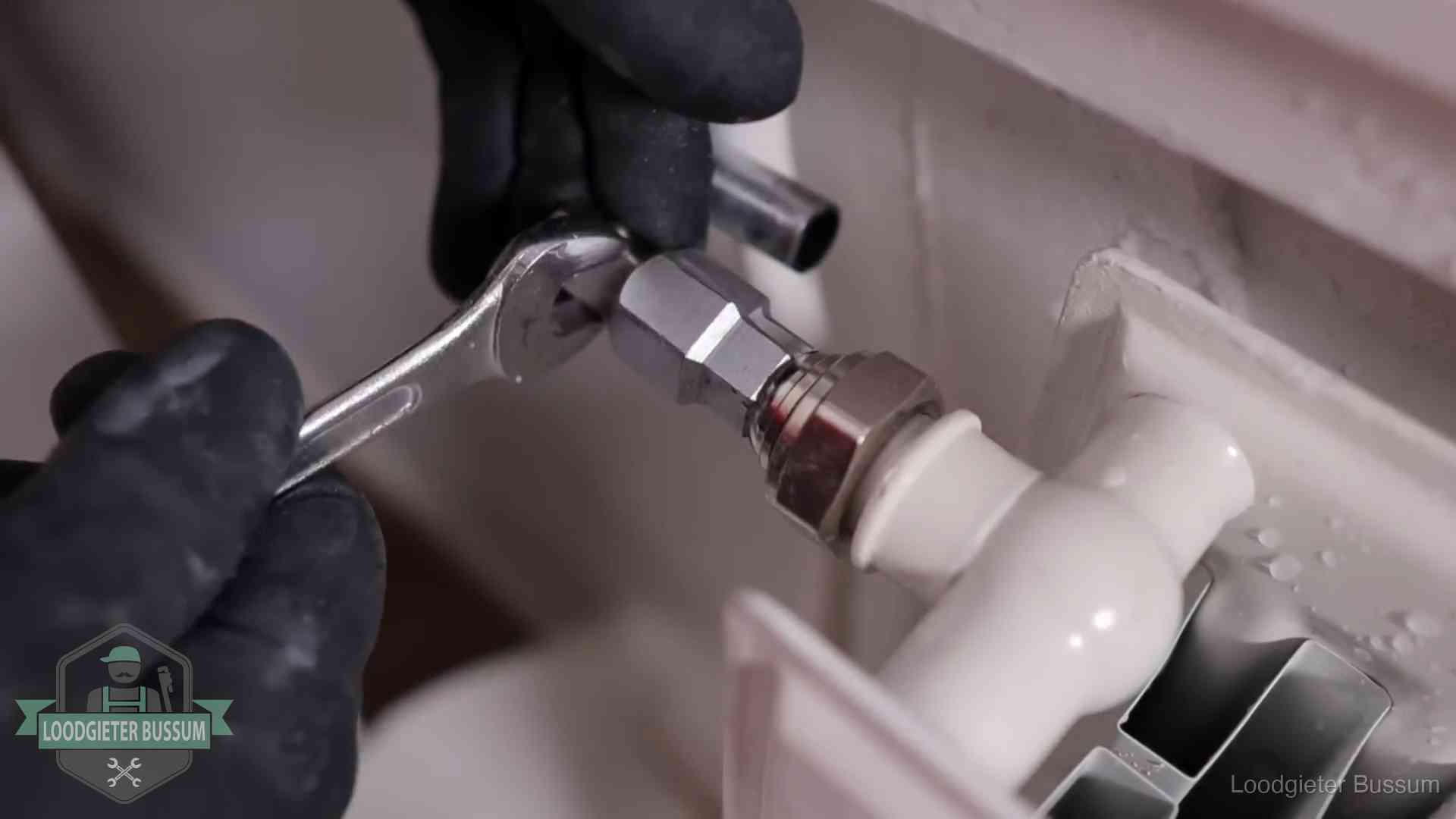 Radiatoren en waterzijdig inregelen in Bussum Steeksleutel draait een wartelkoppeling op een radiatorkraan aan in Bussum