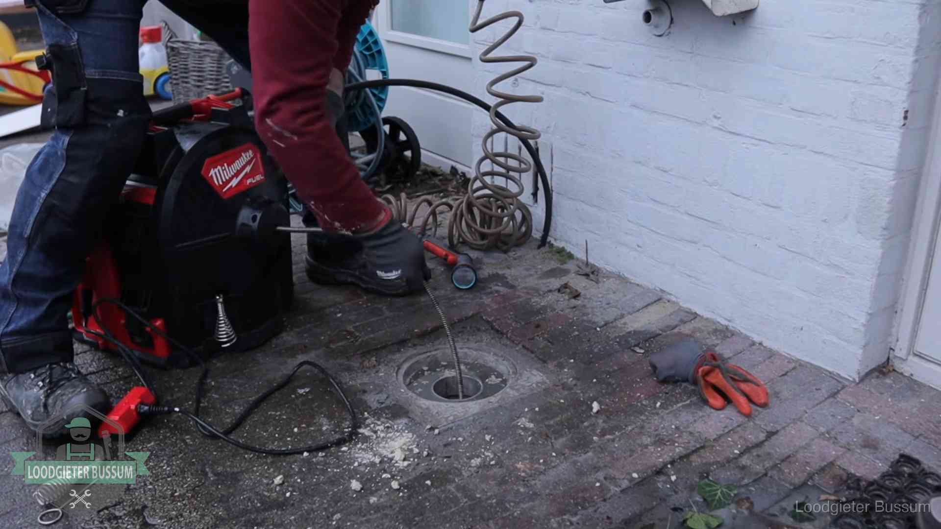 Spiraalmachine bij een ontstoppingsputje in de bestrating in Bussum