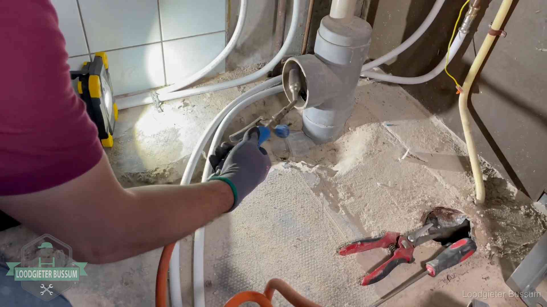 Loodgieter werkt aan leidingen bij een pvc-standleiding in een appartement in Bussum