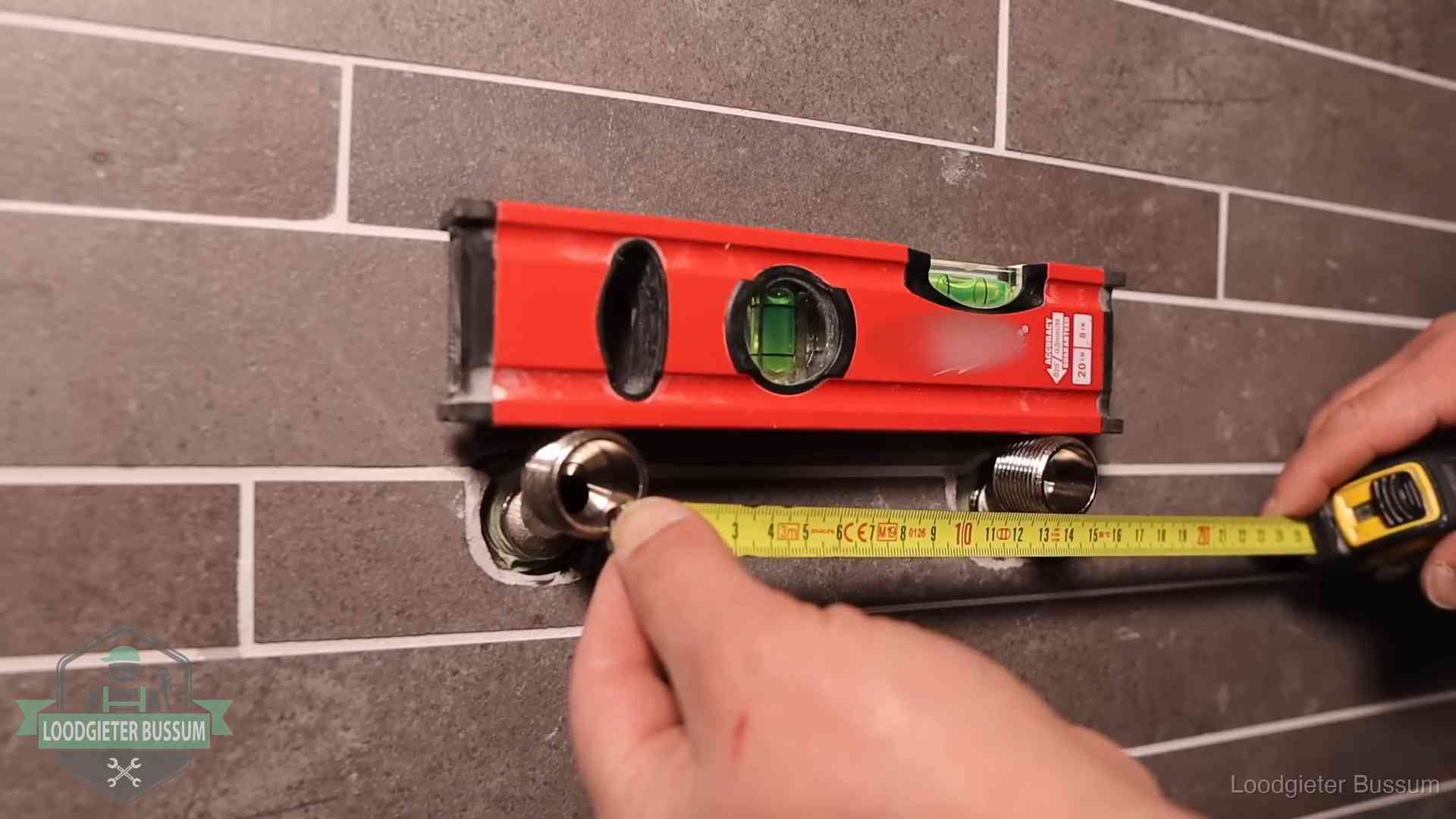 Waterpas en duimstok bij kraan-aansluitpunten in een badkamer in Bussum