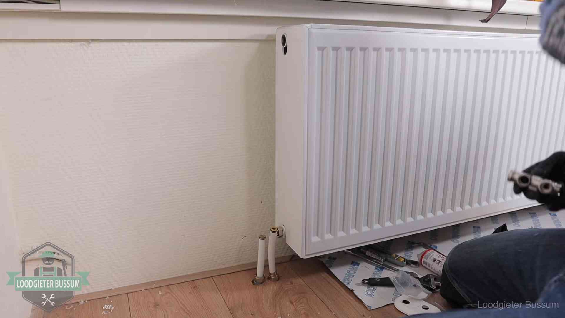 Verwarming per wijk in Bussum Nieuw gemonteerde radiator in een woonkamer in Bussum