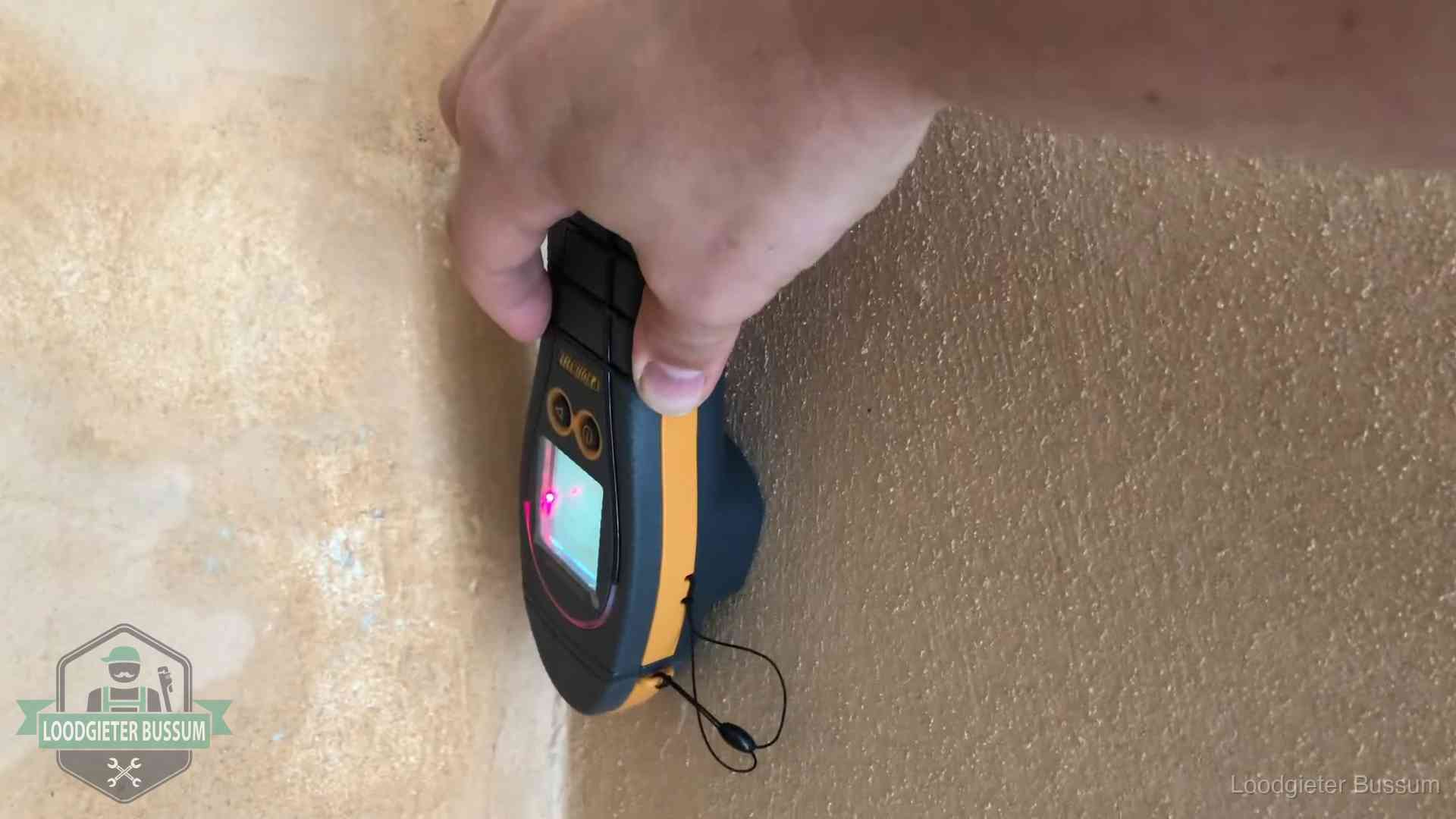 Daklekkage opsporen zonder hakwerk in Bussum Vochtmeter tegen een muur met vochtplekken tijdens het opsporen van een daklekkage in Bussum