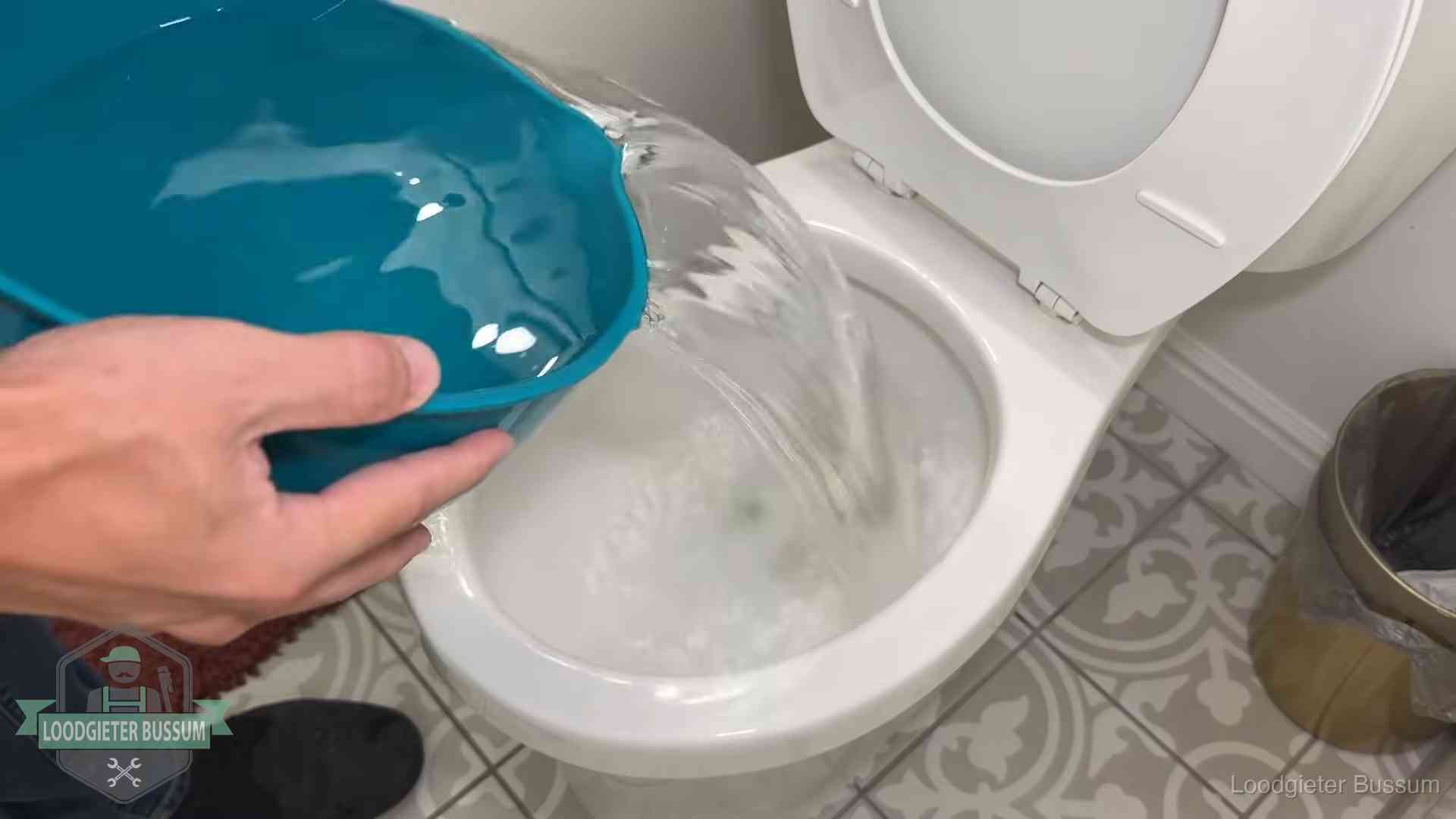Warm water wordt voorzichtig in de wc-pot gegoten in Bussum