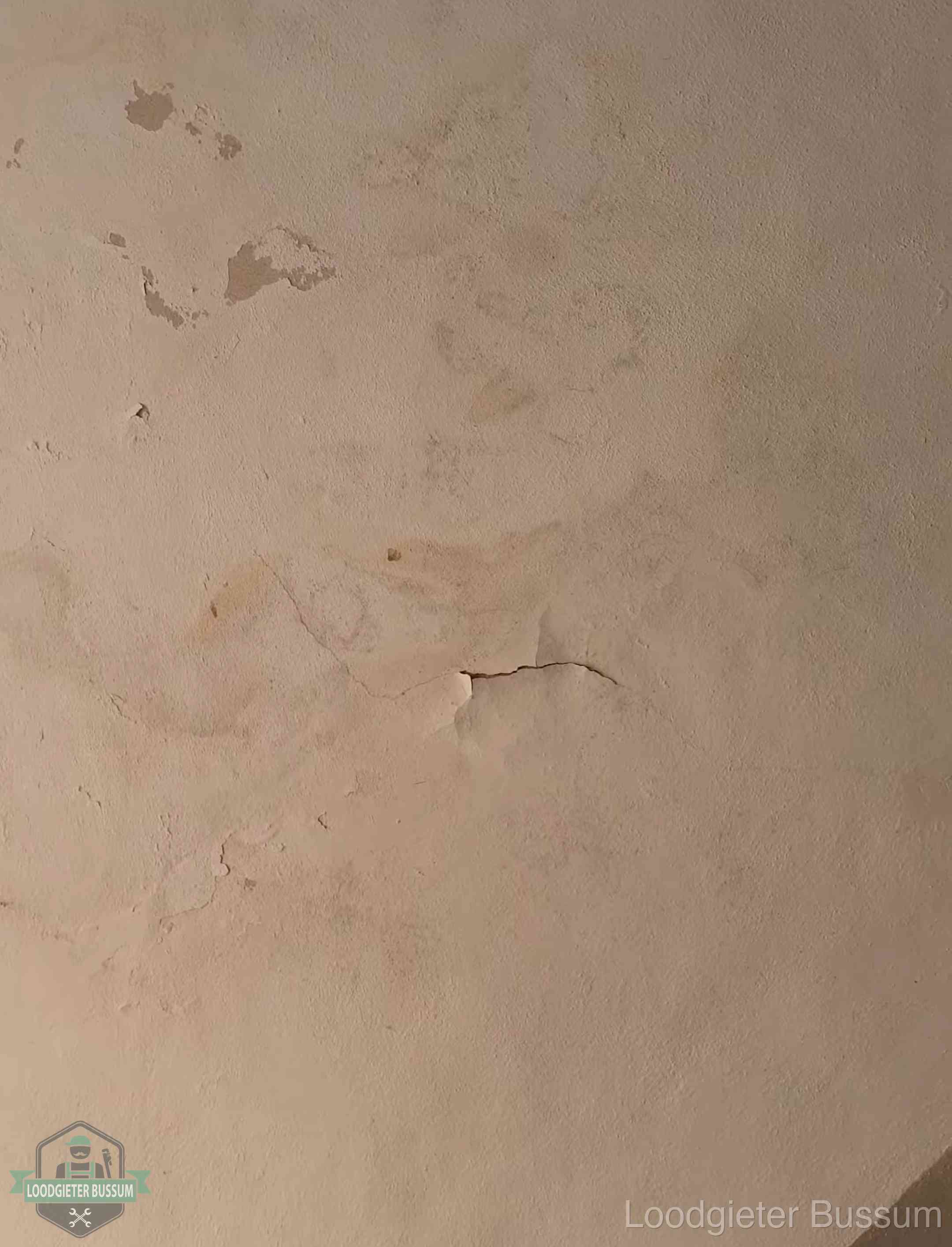 Vochtkringen en afbladderende verf op een plafond in Bussum, schade voor het meetrapport en de verzekering
