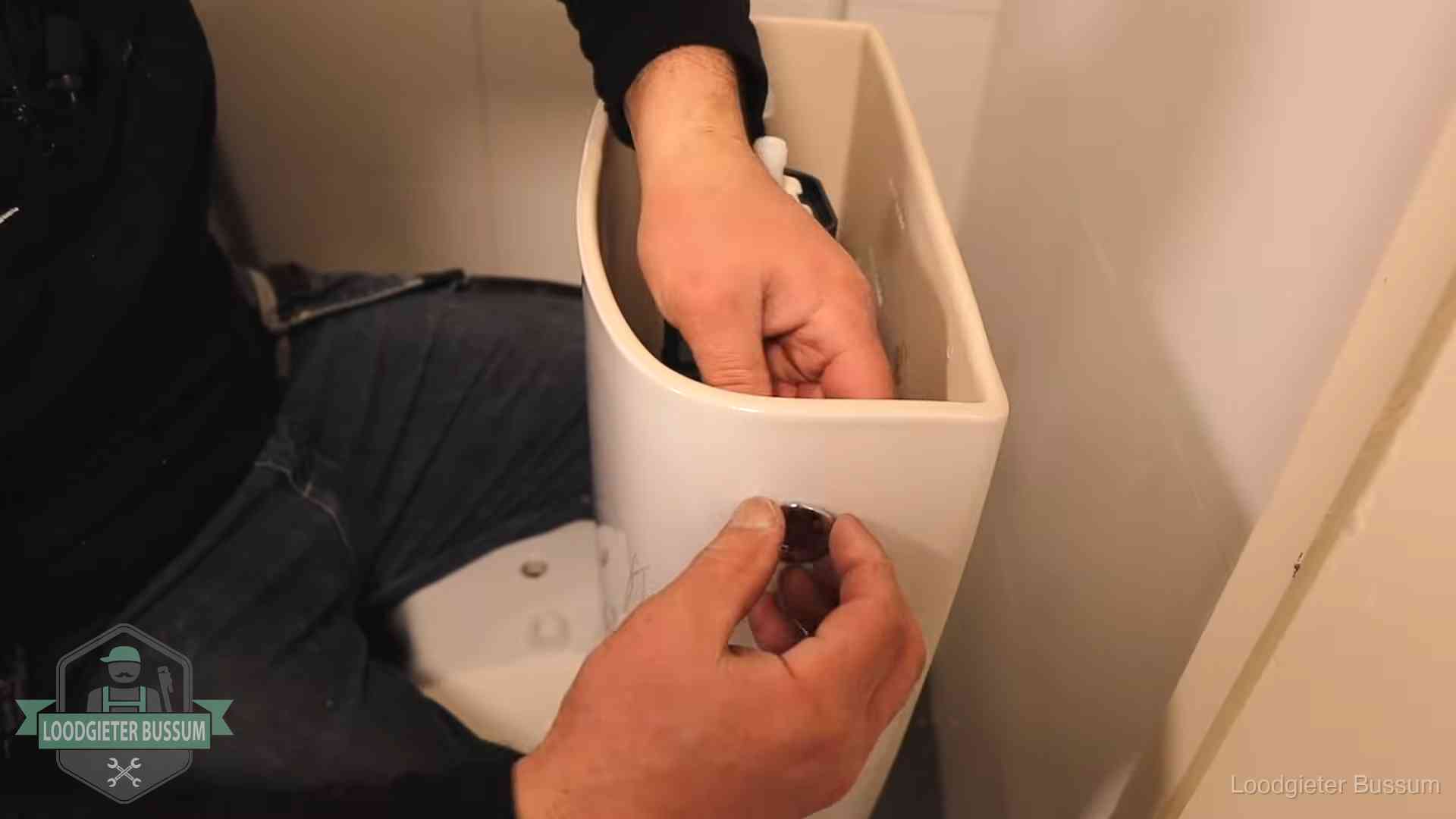 Drukknop van een duoblok-stortbak wordt gemonteerd bij een toilet in Bussum