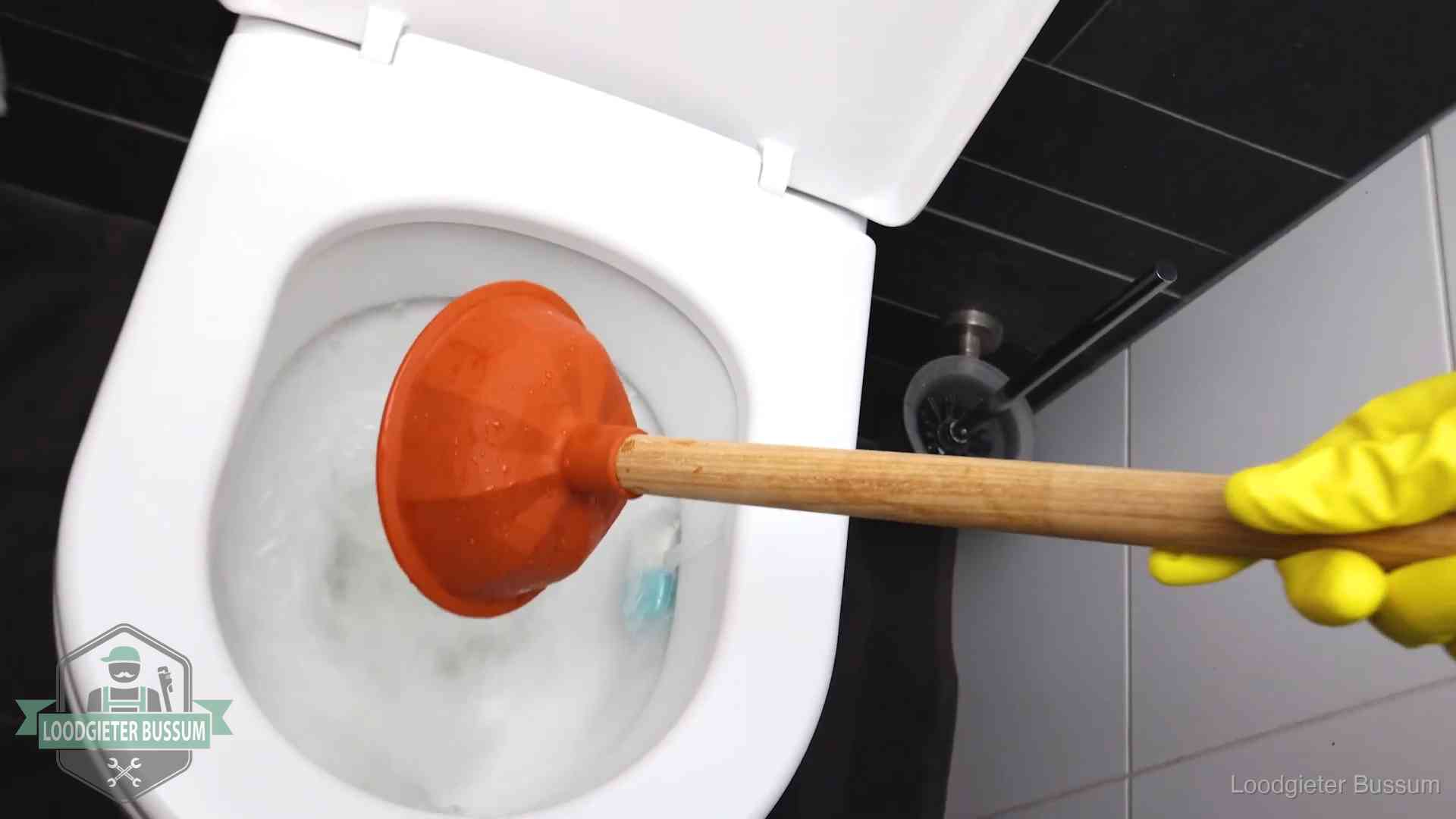 Plopper wordt in de wc-pot gedrukt bij het ontstoppen van een toilet in Bussum