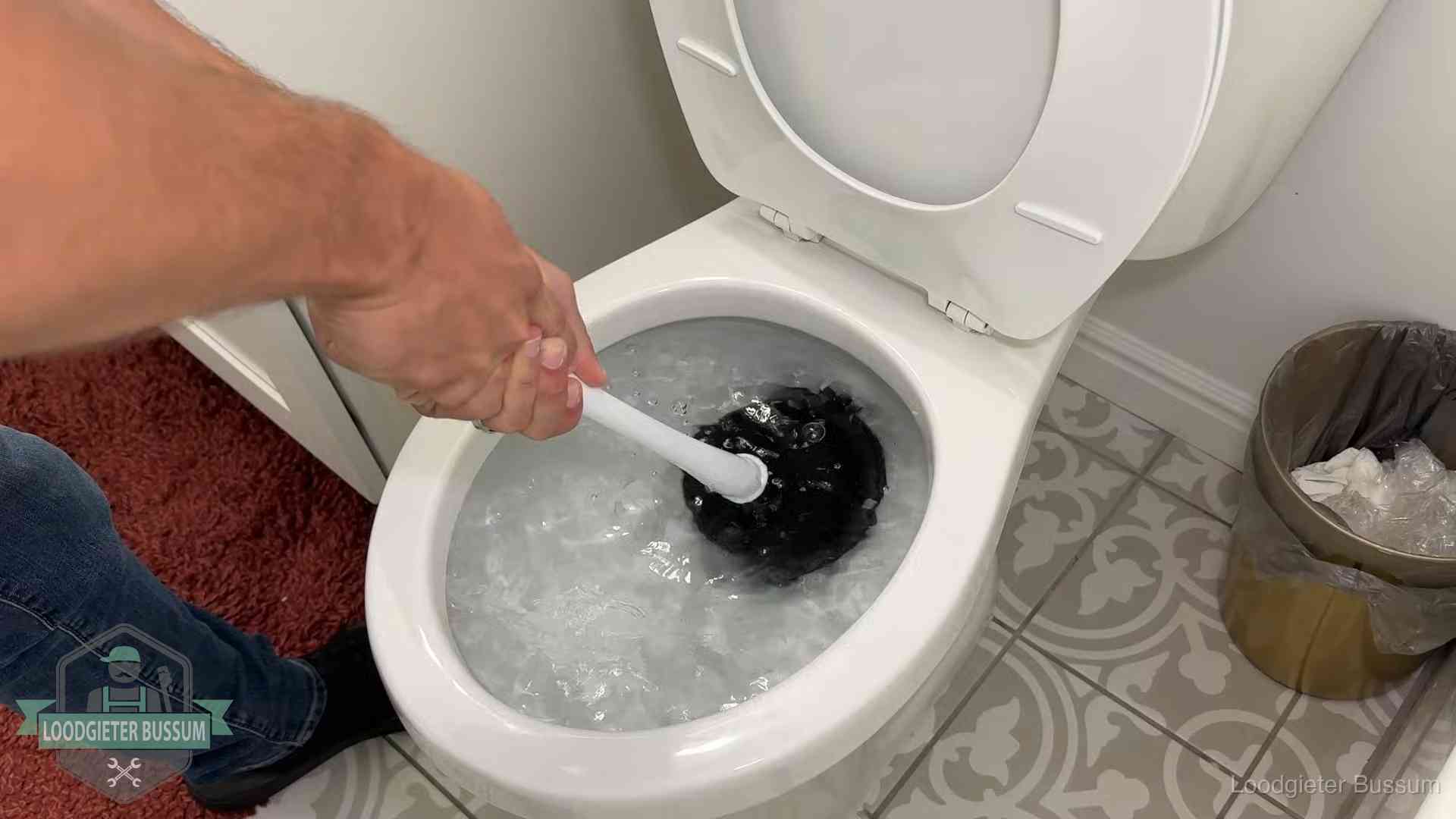 Zelf de wc ontstoppen met een plopper in Bussum, het water kolkt in de pot